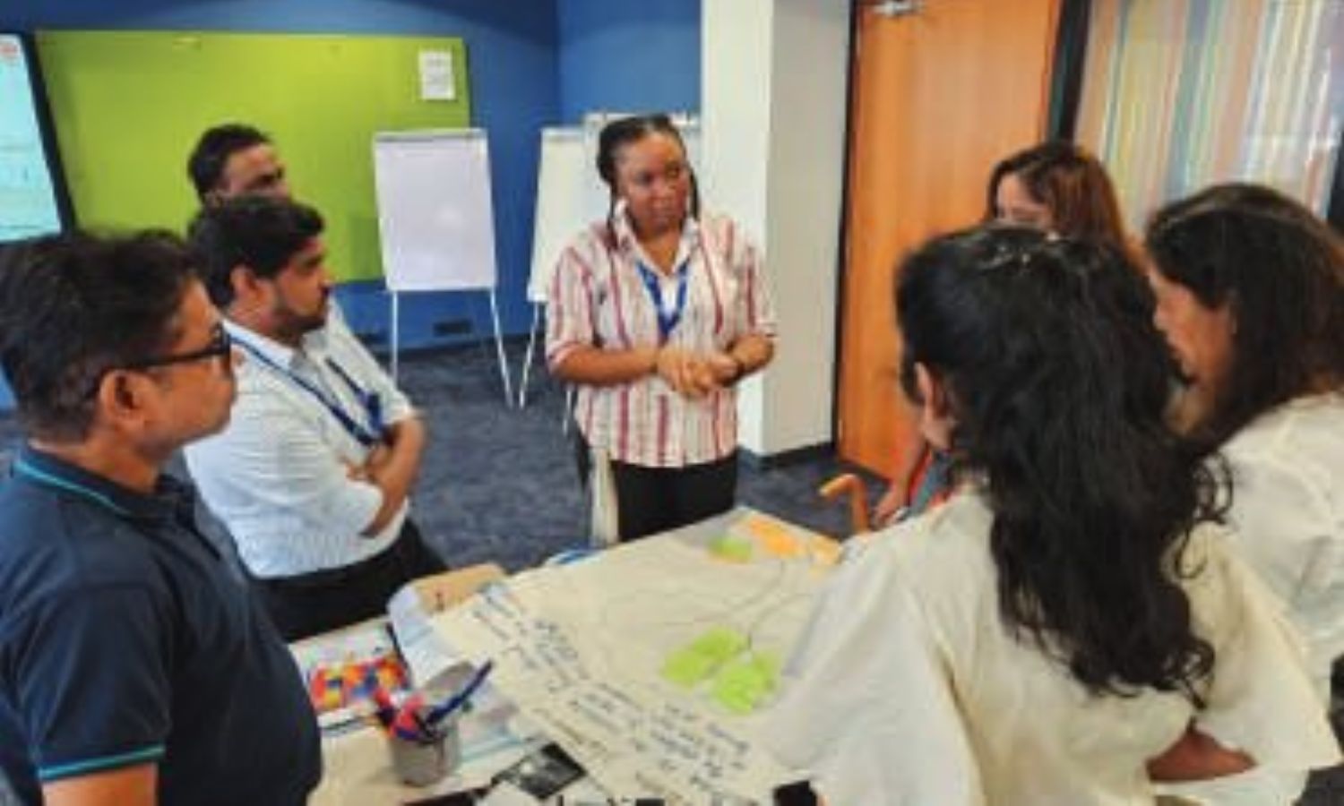 Employees actively engaged in Lean training, collaborating in group activities and presentations to strengthen a culture of continuous improvement